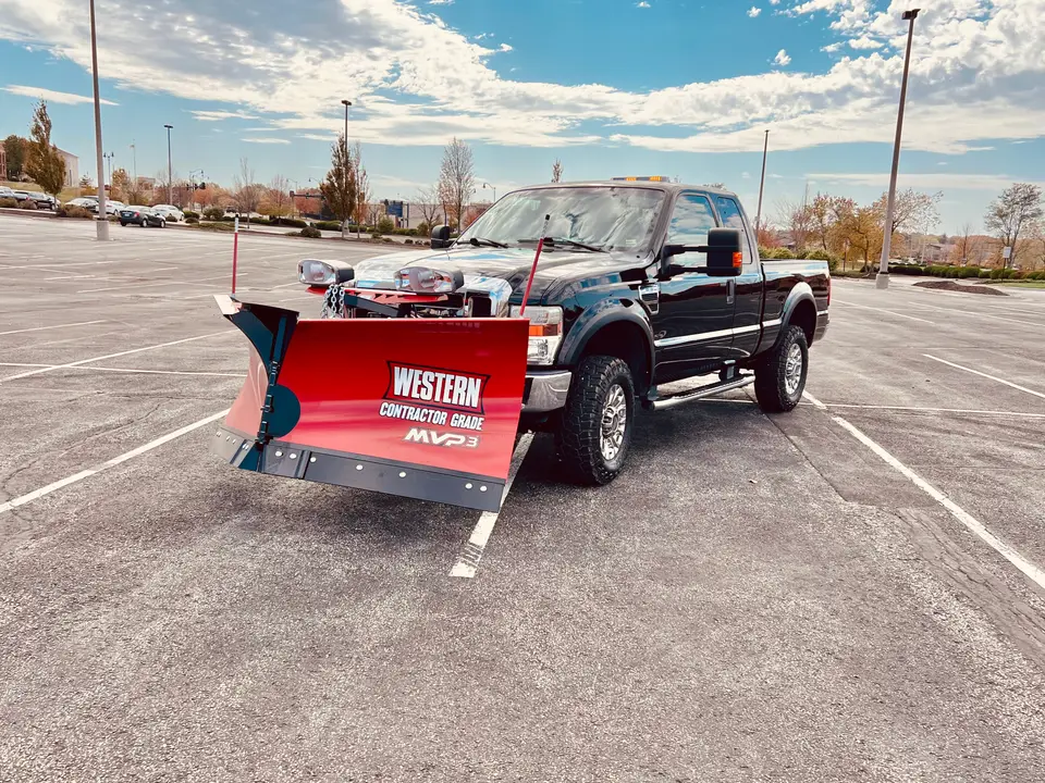 Pickup truck with a red Western snow plow